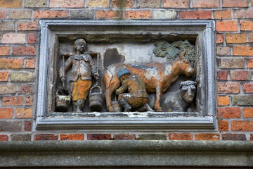 A wall bas relief in Huidenvettersplein (Tanners Square),  representing dairy production, in the historic centre of Bruges, Unesco World Heritage Site, Belgium, Europe