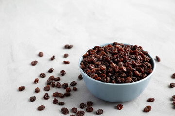 Fototapeta na wymiar Dried Brown Raisins in a Bowl, low angle view. Copy space.