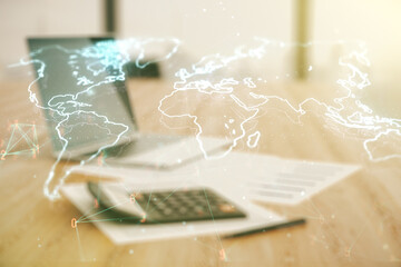 Abstract creative world map interface on calculator and laptop background, international trading concept. Multiexposure