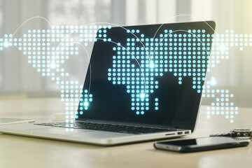 Abstract creative world map with connections on modern laptop background, international trading concept. Multiexposure
