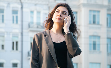 Business young woman with a smartphone on a blurred background of the city.