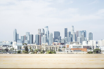 Empty wooden tabletop with beautiful Los Angeles skyscrapers at daytime on background, mock up