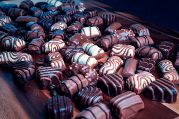 chocolates and coffee roasted beans on wooden table close up
