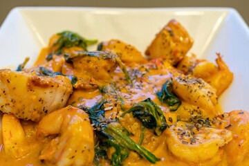 Shrimp and Grits (Polenta) with Scallops in a Tomato Based Sauce with Spinach and Basil
