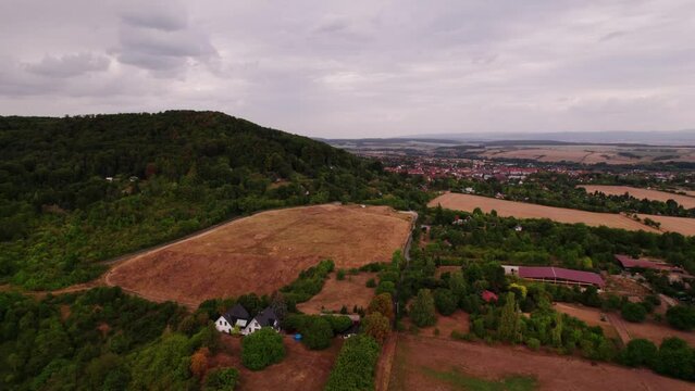 Aer ial view of a German village surrounded by meadows, farmland and forest in Germany.