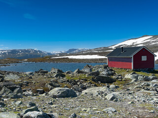 red fisherman's hut at the mountain lake in Norway