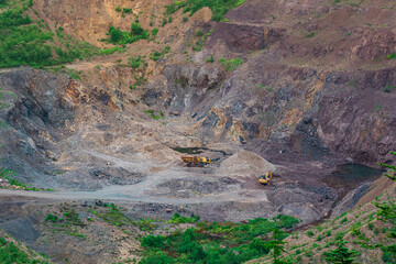 small quarry with mining machinery in mountainous area