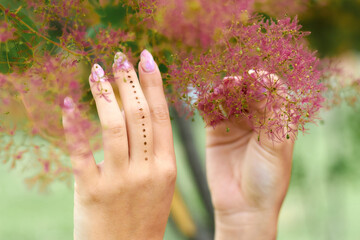 Fototapeta premium Female hands raised up in front of flowering tree, selective focus