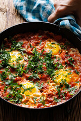 Traditional shakshouka dish served in a pan, close up view.