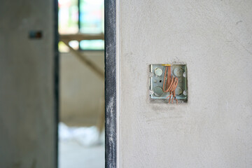 Gray plaster wall with wiring holes in construction house building