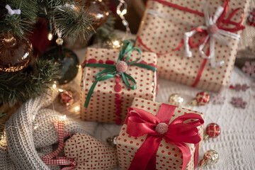 Festive gift boxes under the Christmas tree, close-up.