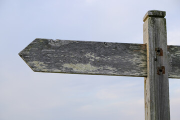 Wooden sign pointing in the correct direction, path