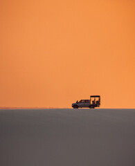 Fototapeta premium silhouette of an offroad car in the desert at sunset