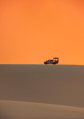 Fototapeta premium silhouette of an offroad car in the desert at sunset