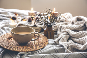 Cozy autumn composition with a big cup of coffee in bed.
