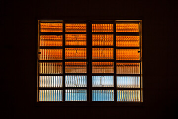 Uma janela de vidro fechada em um quarto escuro. Iluminação do lado de fora.