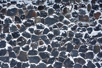 Background of a stone wall covered with snow.