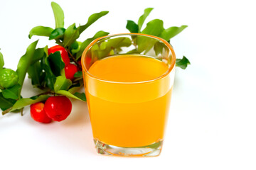 Acerola or barbados cherry juice in glass with fresh acerola cherry fruits isolated on white background.
