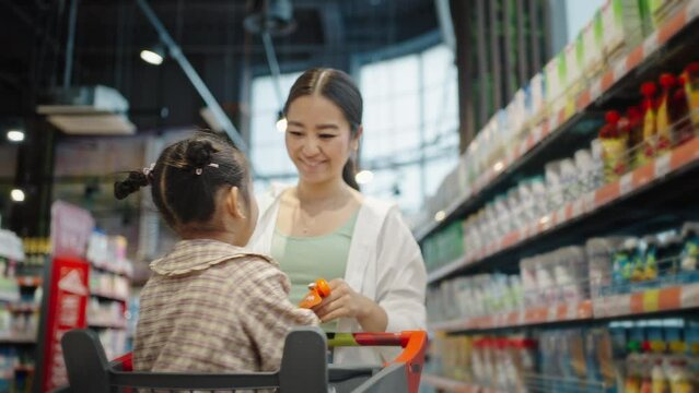 Preschooler girl asks mother to buy bisquits in market