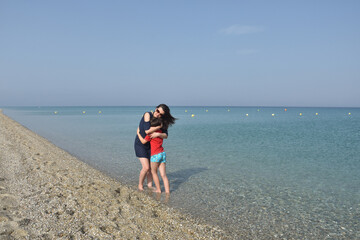 Mother and little boy on the beach. Mom and child hugging and enjoy by the sea