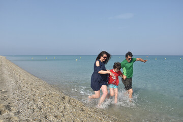 Happy family running and enjoy at beach. Summer vacation, family with one child having fun on sea