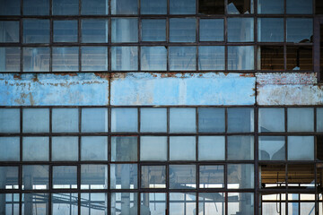 Fototapeta na wymiar Broken glass facade old, industrial, abandoned factory building.