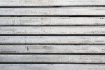 Closeup of garage steel wall texture, horizontal lines pattern, gray vintage striped door, background.