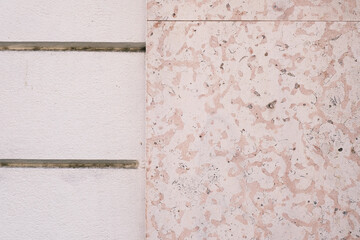 Decorative marble stone tile wall, texture, dirty and aged building facade surface, outside architecture decoration details, background.