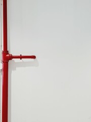 red metal pipe on white wall