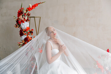 Bald beautiful bride in a luxurious wedding dress in red lipstick and a long veil is sick with...