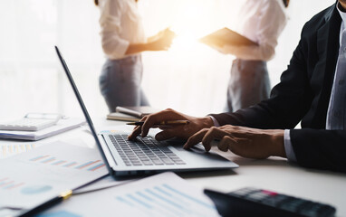 negotiation, analysis, discussion,asian male economist using report explaining the investment finance program to the company owner to plan marketing and hedging business risks.