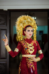 A female model who wears make-up and a traditional wedding dress or attire. Traditional clothing of Bali - Indonesia. Balinese Culture