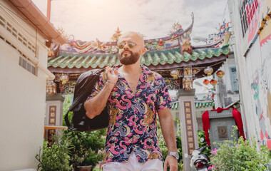 Young man with a backpack on the background of an asian temple