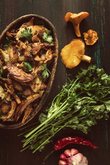Fried chanterelles with mushrooms, in a clay pan, close-up, top view, selective focus,
