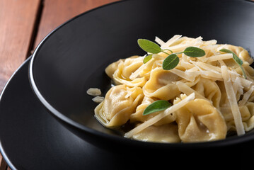 Piatto di tortelli al burro, salvia e scaglie di formaggio, cibo italiano 