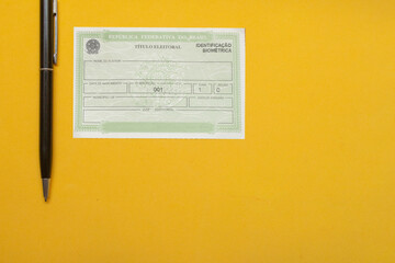  LAURO DE FREITAS, BRAZIL - August 19, 2022 : brazilian election document  near pen under yellow...