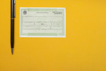  LAURO DE FREITAS, BRAZIL - August 19, 2022 : brazilian election document  near pen under yellow background