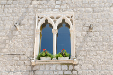 Window of an old stone house in Bol town on Brac, Croatia, Venetian gothic style, architectural detail