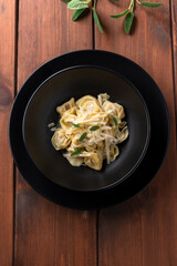 Piatto di tortelli al burro, salvia e scaglie di formaggio, cibo italiano 