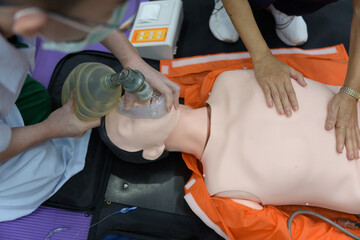 Demonstrating CPR (Cardiopulmonary resuscitation) training medical procedure on CPR doll in the class.Doctor and nurse students are learning how to rescue the patient.First aid for safe life concept. - obrazy, fototapety, plakaty