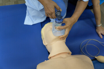 Demonstrating CPR (Cardiopulmonary resuscitation) training medical procedure on CPR doll in the class.Doctor and nurse students are learning how to rescue the patient.First aid for safe life concept.