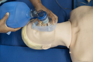 Demonstrating CPR (Cardiopulmonary resuscitation) training medical procedure on CPR doll in the...