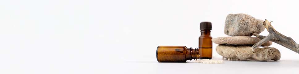 Homeopathy concept with mineral stones, granules and glass bottles on white background 