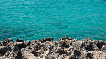 Blue and crystal clear waters of the Mediterranean sea next to the rocks on the island of Mallorca