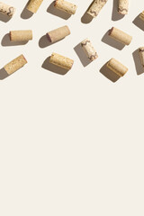 Pattern with wine corks from white and red wine on beige pastel color background with hard light and shadow at sunlight. Trend layout with bottle stoppers, wooden cork, copy space
