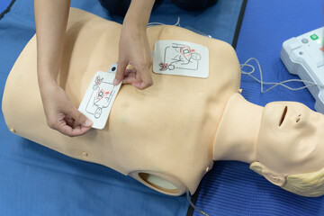 Demonstrating CPR (Cardiopulmonary resuscitation) training medical procedure on CPR doll by...