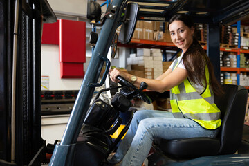 portrait female worker driving a forklift in the warehouse storage © offsuperphoto