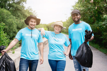 Portrait of volunteers clean discarded garbage and plastic in the forest park area.