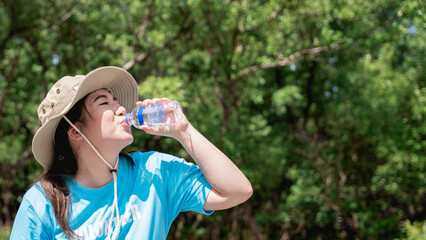 Volunteers drink water after cleaning discarded garbage and plastic in the forest park area.