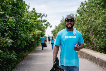 Portrait of volunteers clean discarded garbage and plastic in the forest park area.